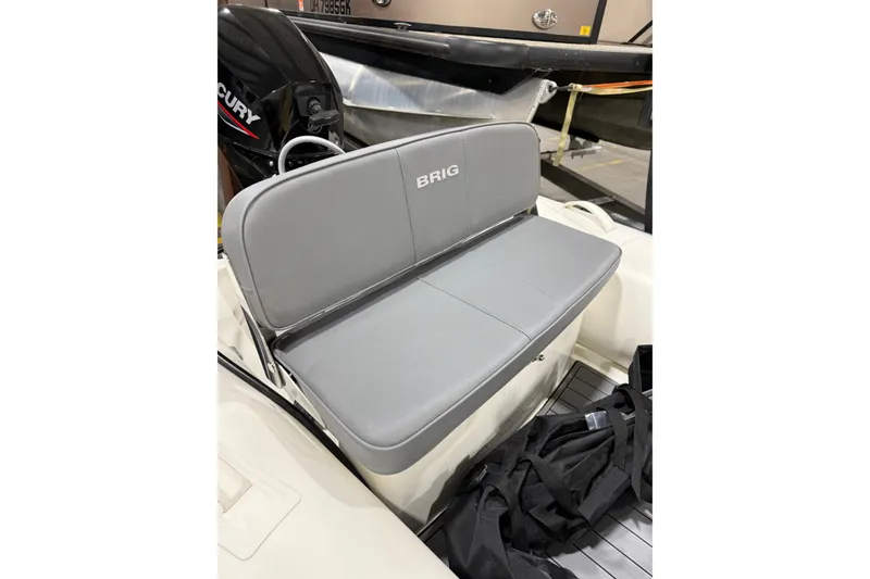 Slide: The Image of 2026 Brig Falcon 330 boat seat with gray upholstery and Mercury engine in background. - 15