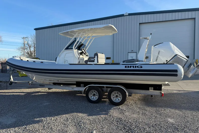 Slide: The Image of 2026 Brig Eagle 8 boat on trailer, parked outside a large garage. - 9
