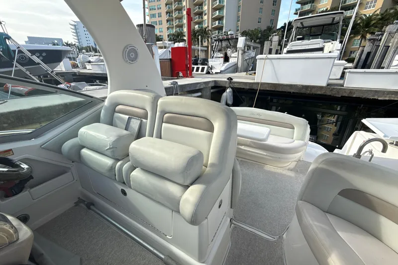 Slide: The Image of 2002 Sea Ray 320 Sundancer interior with plush seating at marina. - 13