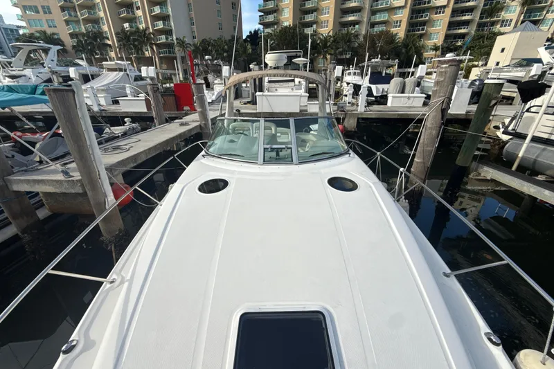 Slide: The Image of 2002 Sea Ray 320 Sundancer docked at marina with surrounding boats and buildings. - 16