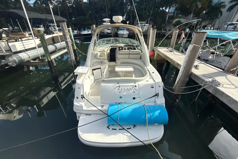 Slide: The Image of 2002 Sea Ray 320 Sundancer docked at marina, rear view with seating area. - 2