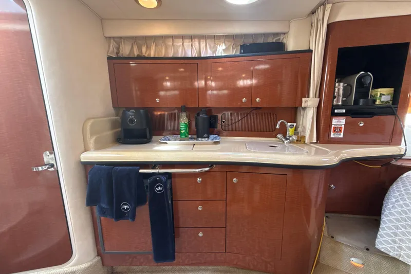 Slide: The Image of 2002 Sea Ray 320 Sundancer interior kitchen with wooden cabinets and modern appliances. - 20