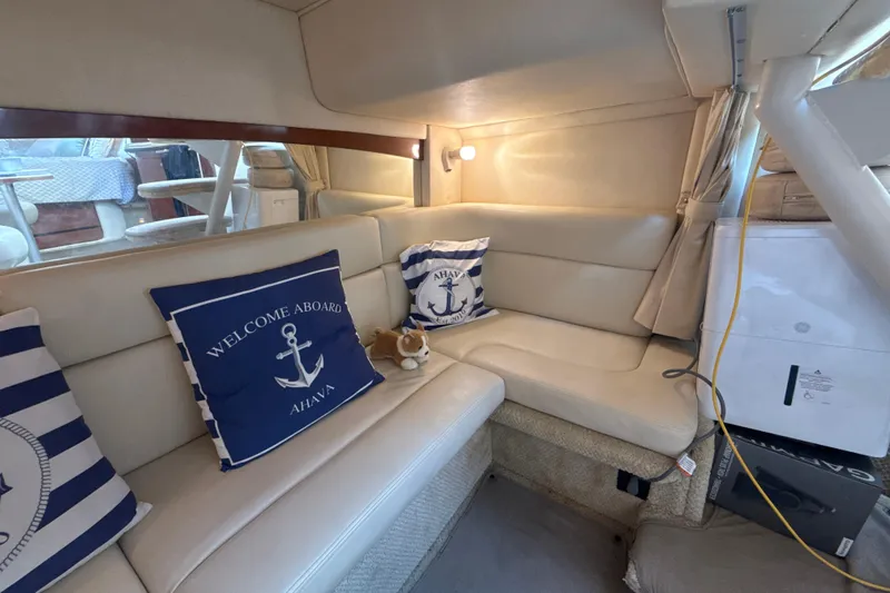 Slide: The Image of Interior of 2002 Sea Ray 320 Sundancer with nautical-themed cushions and cozy seating area. - 23