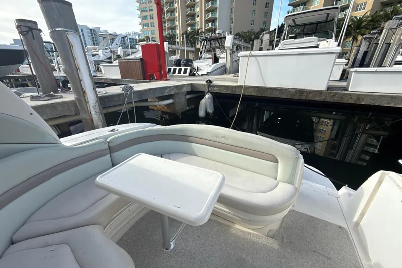 Slide: The Image of 2002 Sea Ray 320 Sundancer interior with seating and table at marina dock. - 4