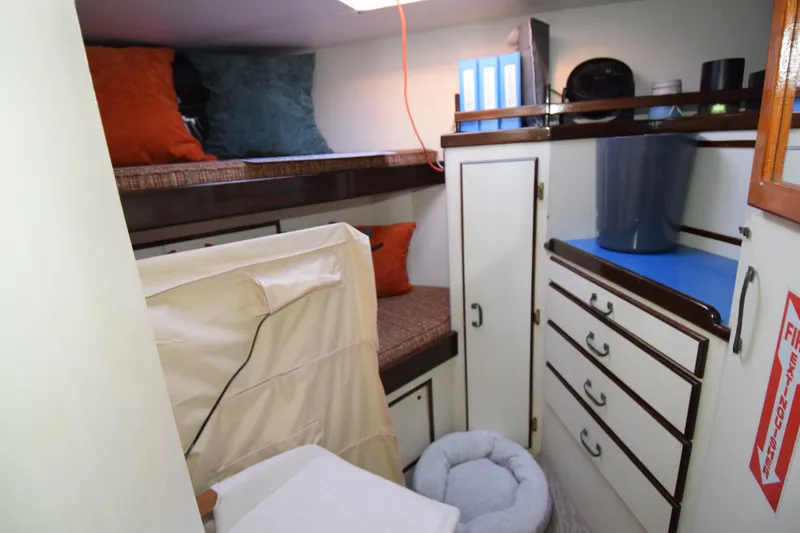 Slide: The Image of 1966 Drake 53 boat cabin with bunk beds, storage drawers, and cozy decor. - 14