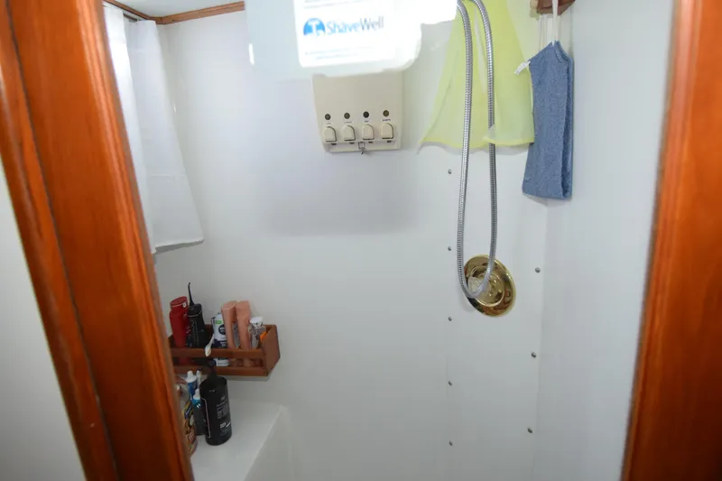 Slide: The Image of Shower area in a 1966 Drake 53 boat with toiletries and wooden accents. - 19