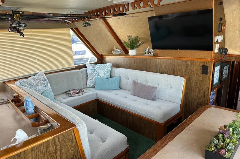 Slide: The Image of Cozy 1966 Drake 53 yacht interior with plush seating, fishing rods, and modern decor. - 23