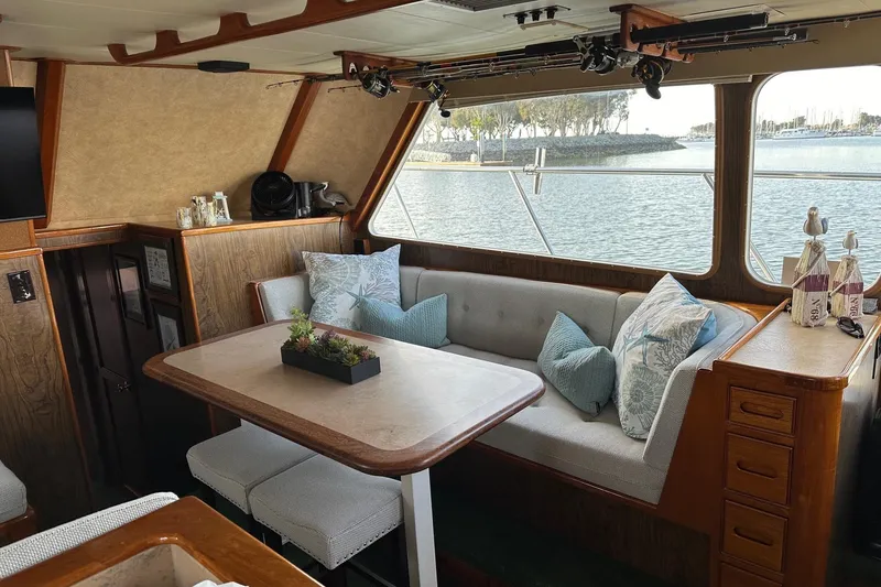 Slide: The Image of Cozy interior of a 1966 Drake 53 boat with dining area and scenic window view. - 24
