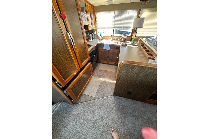 Slide: The Image of Interior of a 1966 Drake 53 boat with wooden cabinetry and kitchen area. - 27