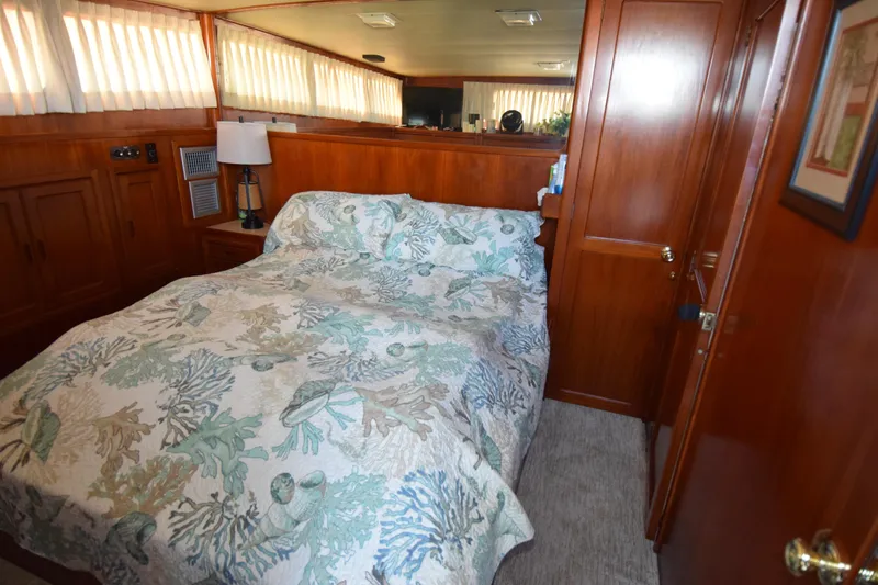 Slide: The Image of Cozy bedroom in a 1966 Drake 53 yacht with wood paneling and patterned bedding. - 8