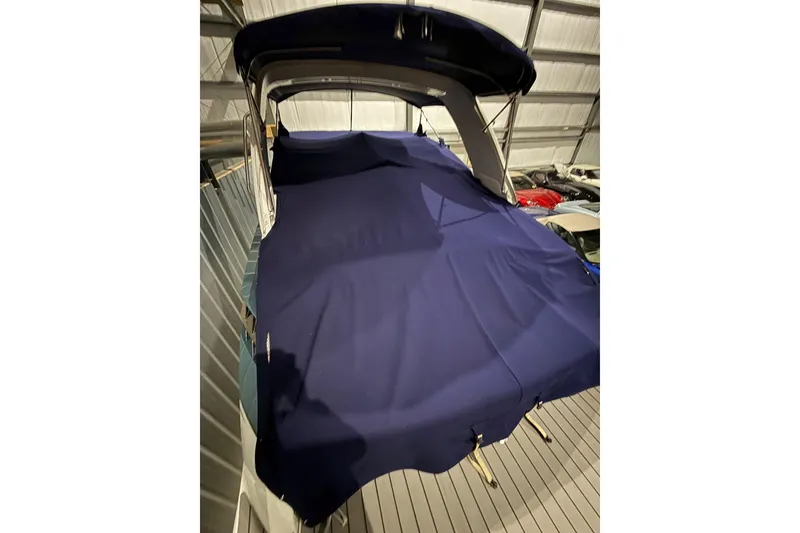 Slide: The Image of 2023 Formula 330 Crossover Bowrider I/O covered in blue tarp, stored indoors. - 6