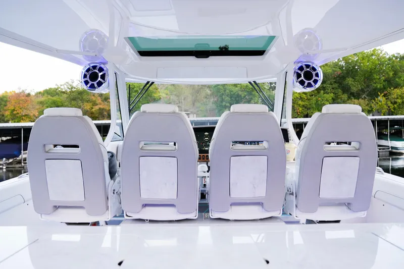Slide: The Image of 2021 Regal 38 SAV boat interior with four white seats and modern audio system. - 12
