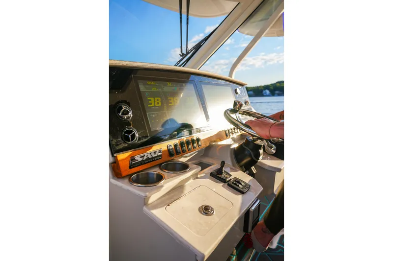 Slide: The Image of 2021 Regal 38 SAV boat dashboard with steering wheel and digital display. - 14