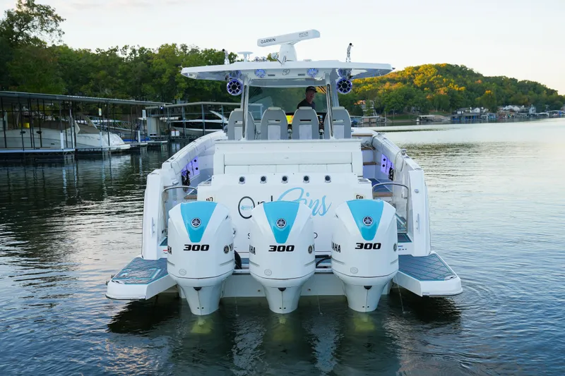 Slide: The Image of 2021 Regal 38 SAV boat with triple Yamaha 300 engines on a serene lake. - 4