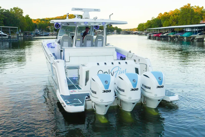 Slide: The Image of 2021 Regal 38 SAV boat with Yamaha engines on a serene lake. - 5