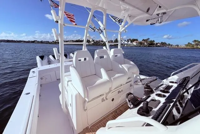 Slide: The Image of 2017 Regulator 41 boat interior with white seating, rod holders, and ocean view. - 30