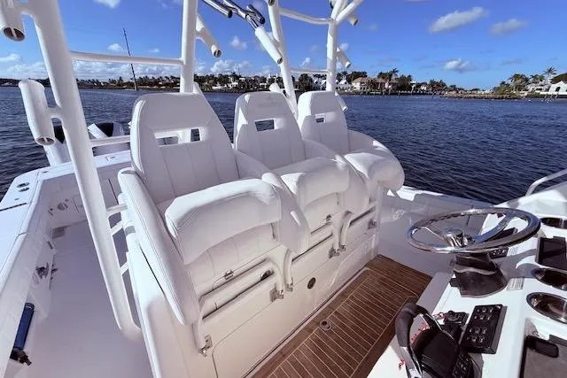 Slide: The Image of 2017 Regulator 41 boat interior with white seating and steering wheel on a sunny day. - 31