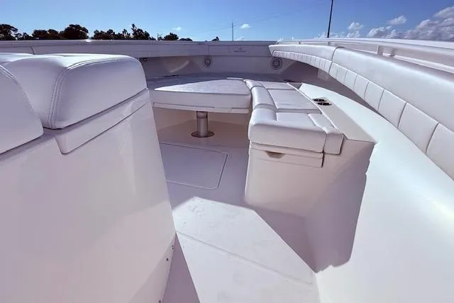 Slide: The Image of 2017 Regulator 41 boat interior with white seating and table under clear blue sky. - 36