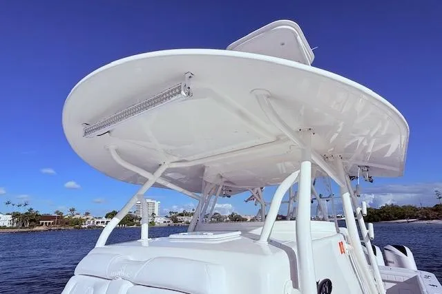 Slide: The Image of 2017 Regulator 41 boat with T-top, under clear blue sky, near waterfront. - 38