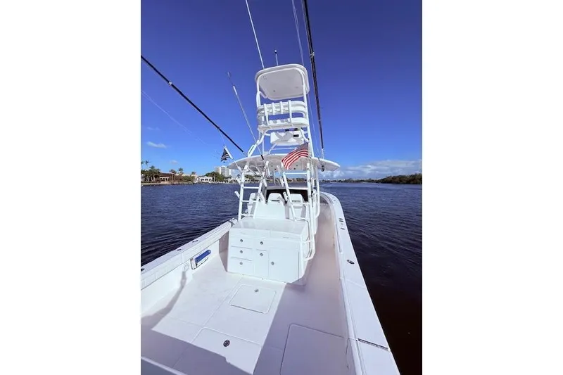 Slide: The Image of 2017 Regulator 41 boat on water, featuring a spacious deck and tower under clear blue skies. - 51