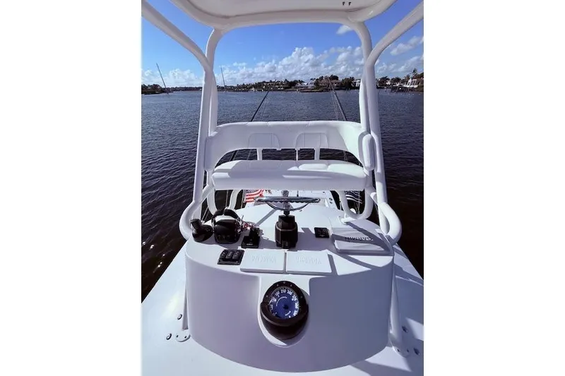 Slide: The Image of 2017 Regulator 41 boat helm with steering wheel and controls, overlooking calm waters. - 70