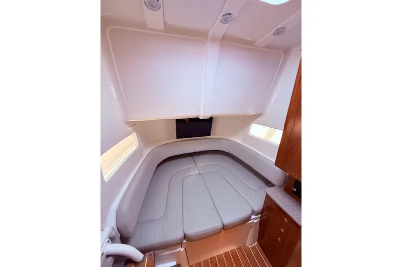 Slide: The Image of 2017 Regulator 41 boat interior with cushioned seating and wood accents. - 72