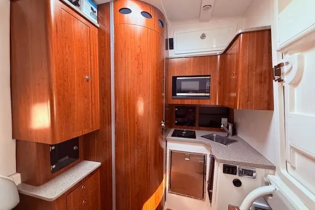 Slide: The Image of Luxurious 2017 Regulator 41 yacht interior with wood cabinetry and modern kitchen amenities. - 75