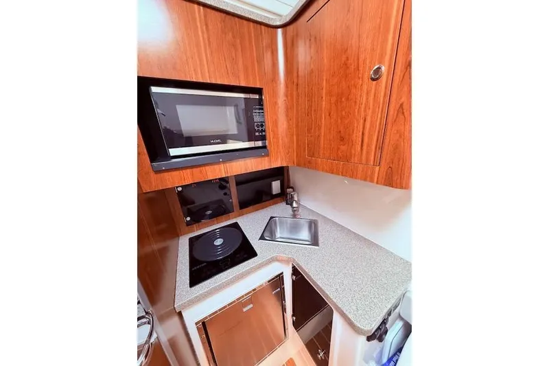 Slide: The Image of 2017 Regulator 41 boat kitchen with microwave, sink, and stove. - 76