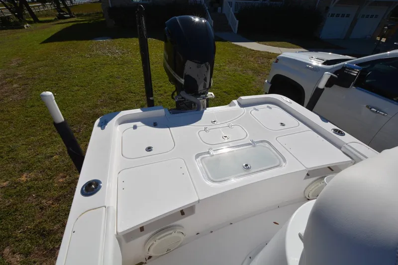 Slide: The Image of 2013 Contender 25 Bay boat with motor, parked on grass beside a white truck. - 10