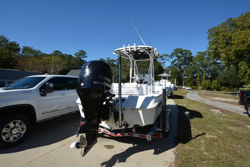Slide: The Image of 2013 Contender 25 Bay boat with Yamaha engine on trailer, parked beside a white truck. - 3