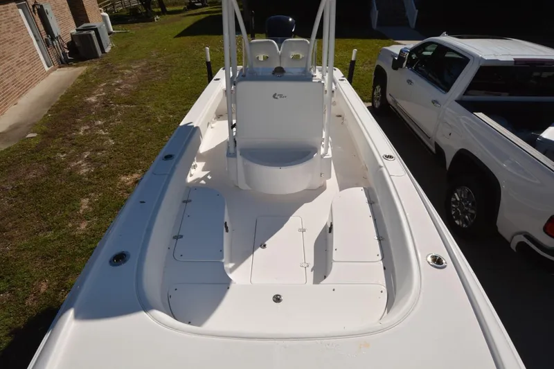 Slide: The Image of 2013 Contender 25 Bay boat with spacious deck, parked beside a white truck. - 5