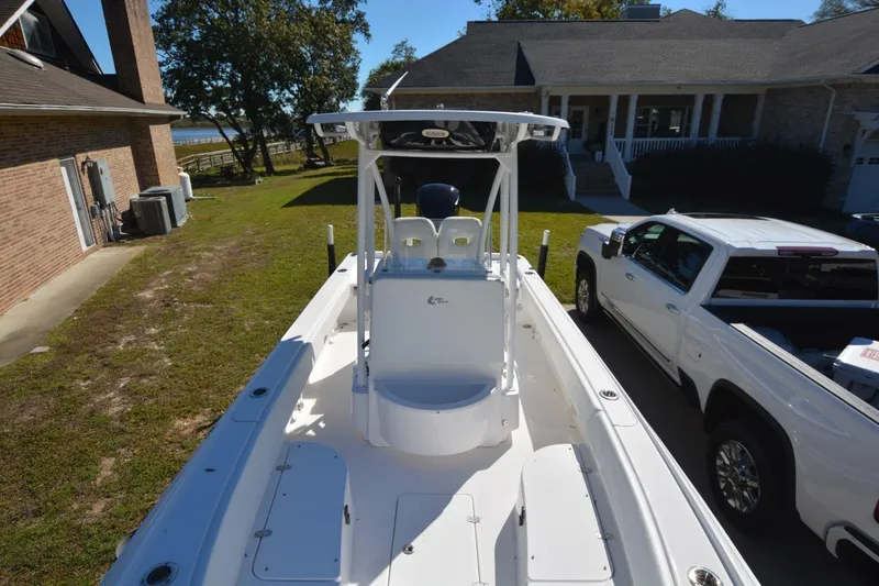 Slide: The Image of 2013 Contender 25 Bay boat parked beside a house and truck. - 6