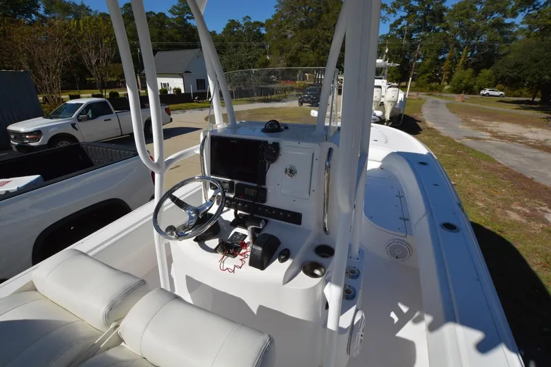 Slide: The Image of 2013 Contender 25 Bay boat interior with steering console and seating, parked outdoors. - 7