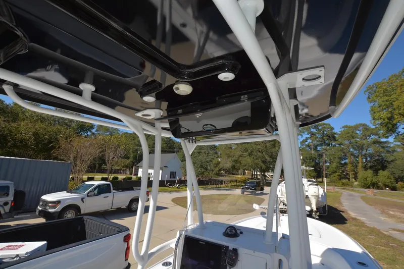 Slide: The Image of 2013 Contender 25 Bay boat with T-top and console, parked outdoors. - 8