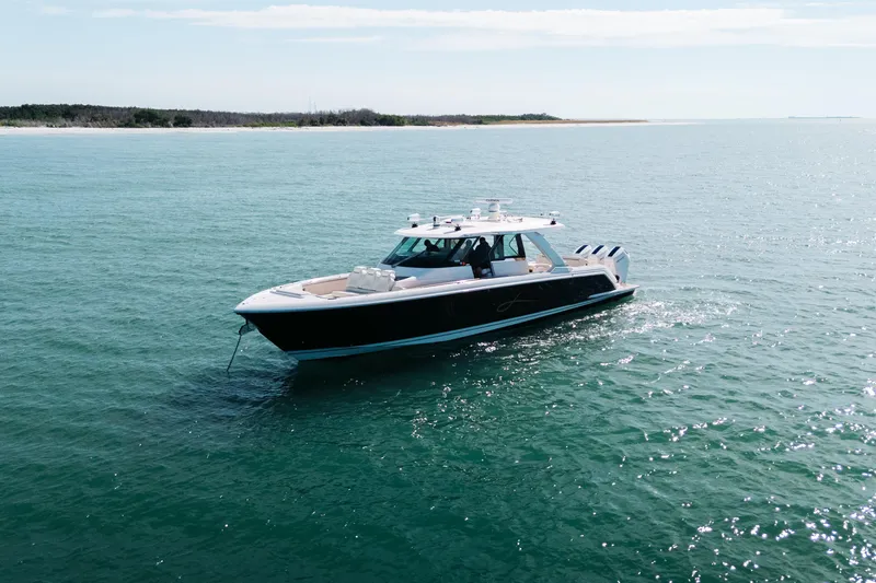 Slide: The Image of 2023 Tiara 48 yacht cruising on open water under clear skies. - 12