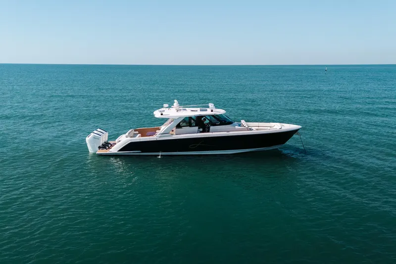 Slide: The Image of 2023 Tiara 48 yacht cruising on open sea under clear blue sky. - 13