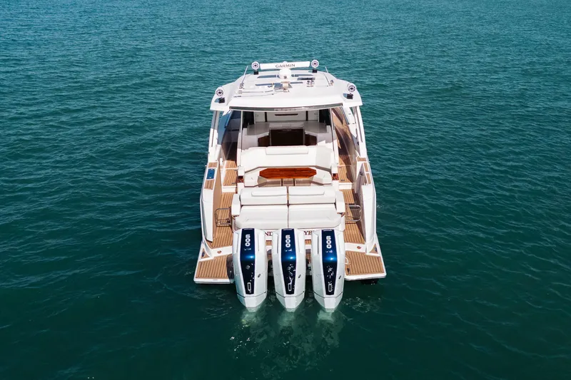 Slide: The Image of 2023 Tiara 48 yacht with triple outboard engines on open water. - 16