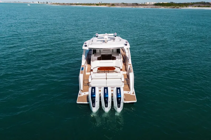 Slide: The Image of 2023 Tiara 48 yacht with triple outboard engines on open water. - 17