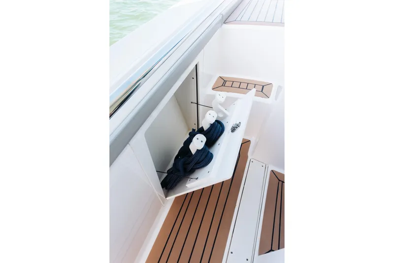Slide: The Image of 2023 Tiara 48 boat storage compartment with ropes, featuring teak flooring. - 21