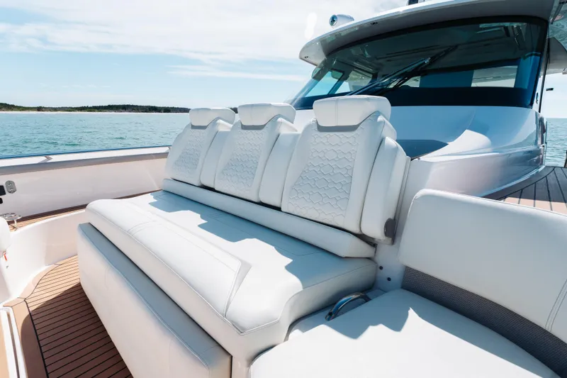 Slide: The Image of Luxurious seating on 2023 Tiara 48 yacht, featuring elegant white upholstery and scenic ocean backdrop. - 24