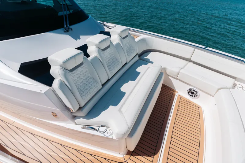 Slide: The Image of Luxurious seating on 2023 Tiara 48 yacht, featuring elegant white upholstery and teak flooring. - 25