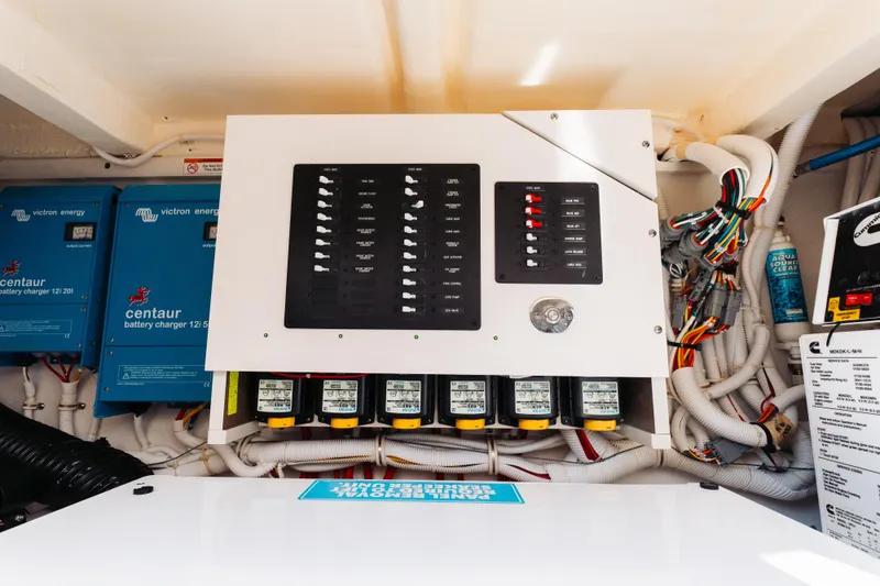 Slide: The Image of Electrical panel and battery chargers in a 2023 Tiara 48 yacht engine room. - 28