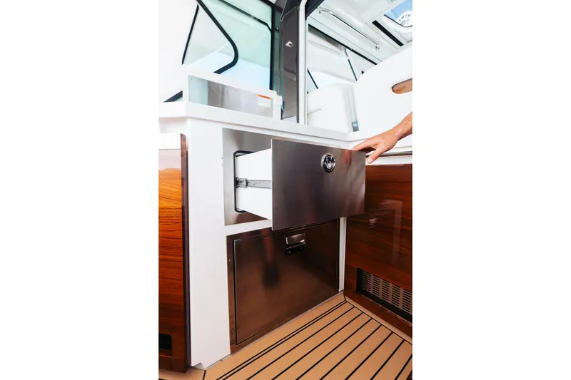 Slide: The Image of 2023 Tiara 48 yacht interior with open stainless steel drawer and wooden flooring. - 33
