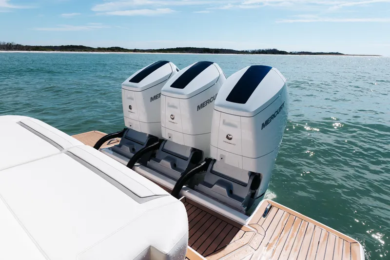 Slide: The Image of 2023 Tiara 48 boat with triple Mercury outboard engines on open water. - 35