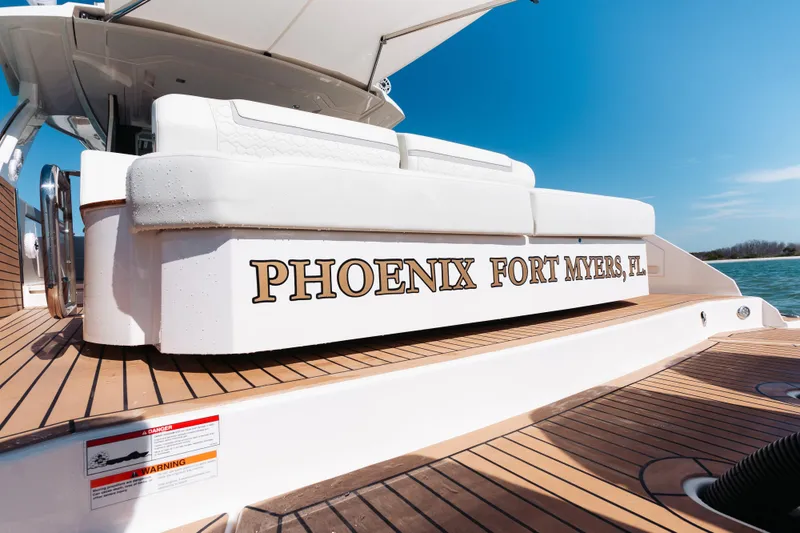Slide: The Image of 2023 Tiara 48 yacht with "Phoenix Fort Myers, FL" on deck, sunny day. - 36