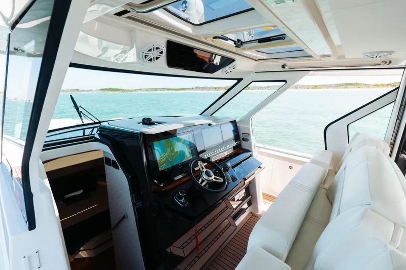 Slide: The Image of 2023 Tiara 48 yacht interior with modern helm and panoramic ocean view. - 50