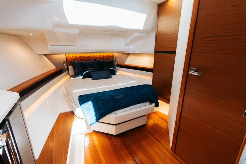 Slide: The Image of Luxurious cabin interior of 2023 Tiara 48 yacht with elegant wood finishes and cozy bedding. - 61