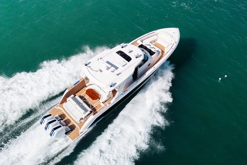 Slide: The Image of Aerial view of 2023 Tiara 48 yacht cruising on turquoise waters. - 9