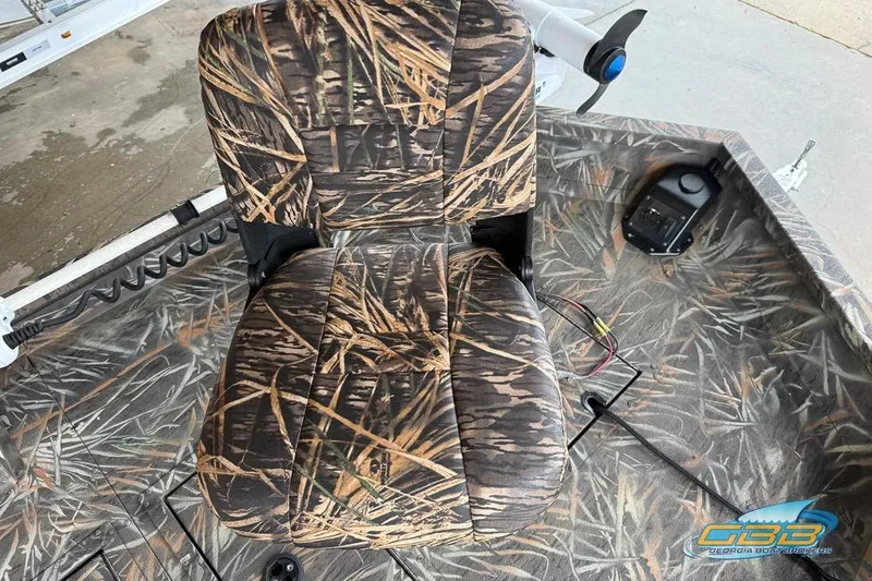 Slide: The Image of 2022 SeaArk 180 RXT boat interior with camo seating and steering wheel. - 13