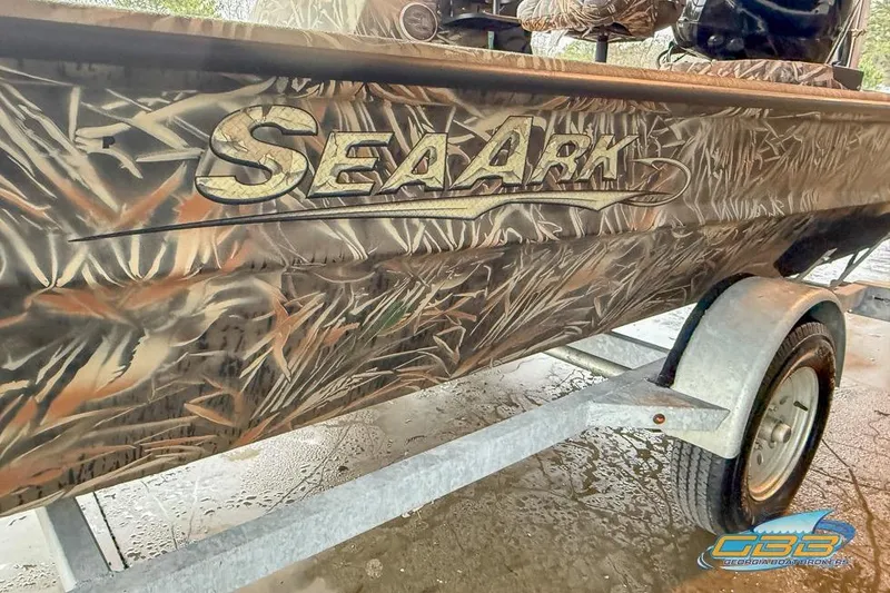 Slide: The Image of 2022 SeaArk 180 RXT boat with camouflage interior, parked in a showroom. - 15